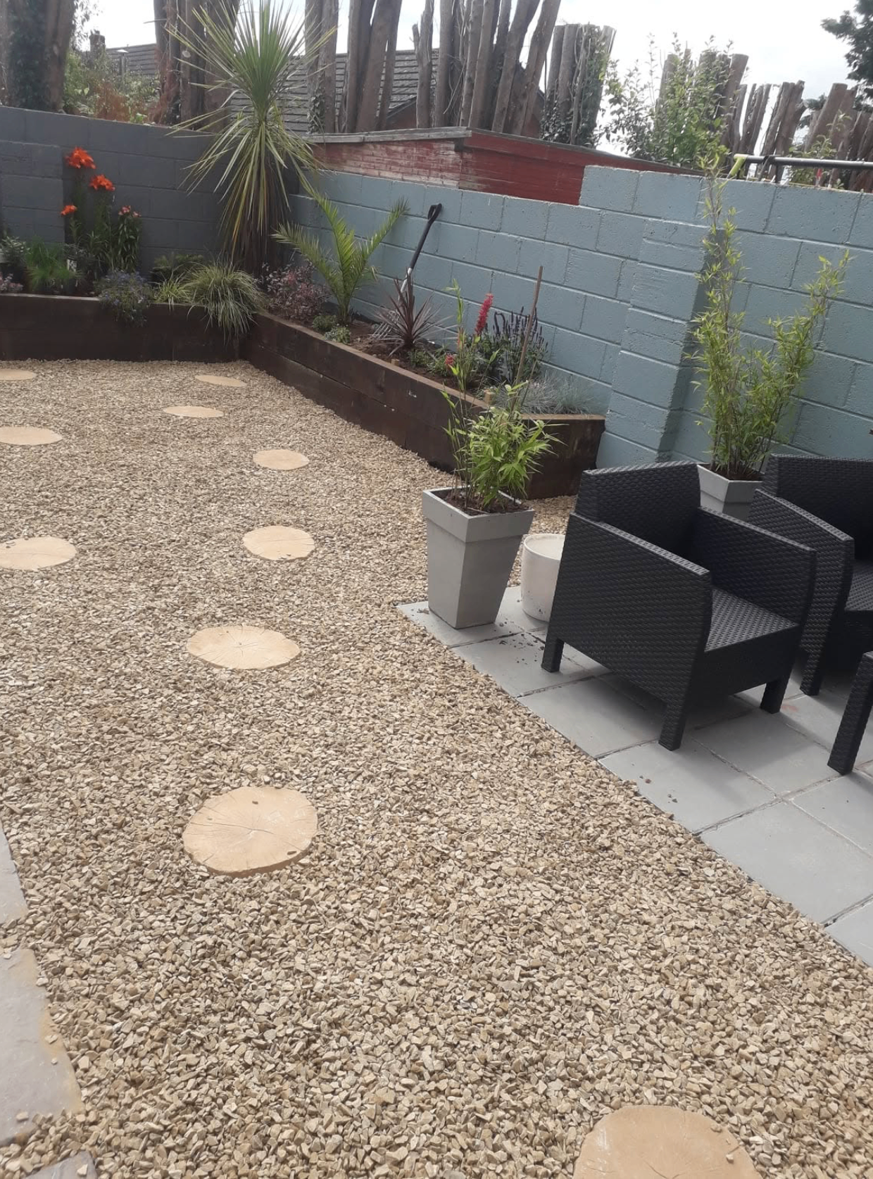 Gravel garden with stepping stones, raised sleeper beds and patio seating area